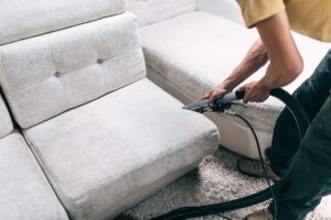 Person using a microfiber cloth and squeegee to clean a large residential window on a sunny day
